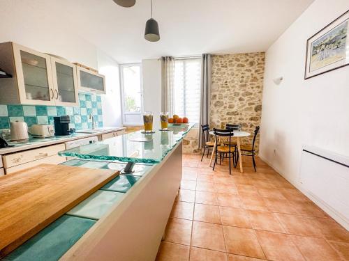 une cuisine avec un comptoir et une table à l'intérieur dans l'établissement Cozy - Centre Historique - Gare à proximité - Grande Terrasse, à Béziers