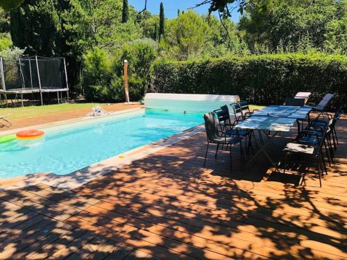 - une table et des chaises à côté de la piscine dans l'établissement Appartement en rez de jardin d'une bastide proche centre d'Aix!, au Tholonet