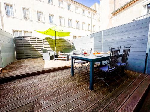a table and chairs on a deck with an umbrella at Cozy - Centre Historique - Gare à proximité - Grande Terrasse in Béziers