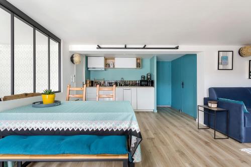 a living room with a table and a kitchen at Appartement 56m2 avec terrasse au calme & borne électrique in Dardilly