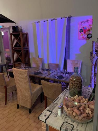 a dining room with a table with chairs and a bottle at LOGIS HOTELS - Hôtel et Restaurant L'Océana in Lanton