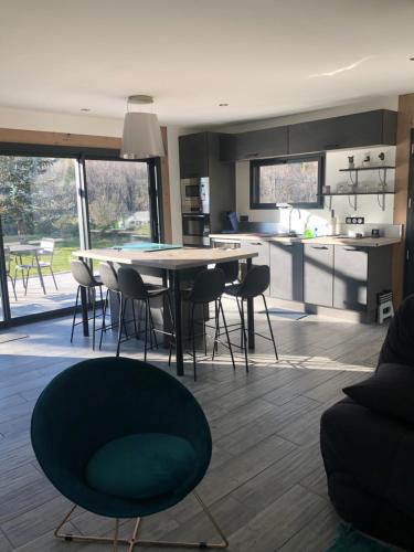une cuisine et un salon avec une table et des chaises dans l'établissement Gîte Ô près Ô, à La Souche