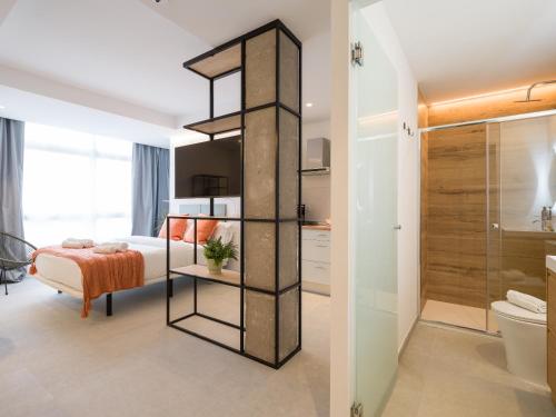 a bedroom with a bed and a bathroom with a shower at Shabolo Apartments Las Palmas in Las Palmas de Gran Canaria