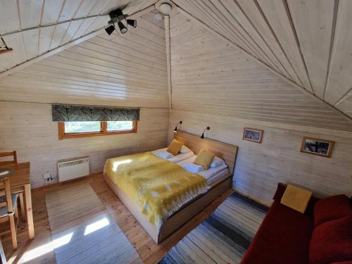 - une chambre avec un lit dans une pièce en bois dans l'établissement Reindeer Lodge, à Jukkasjärvi