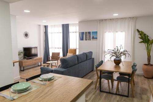 ein Wohnzimmer mit einem Sofa und einem Tisch in der Unterkunft Calvario 53 by 7Escalones in Rota
