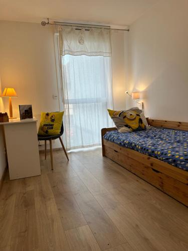 une chambre avec un lit et une grande fenêtre dans l'établissement Appartement Annecy Green, à Annecy