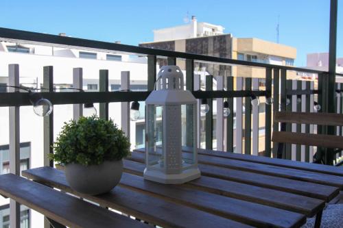 a wooden bench with a light and a plant on a balcony at Experiencia Premium en la Esencia de Denia in Denia