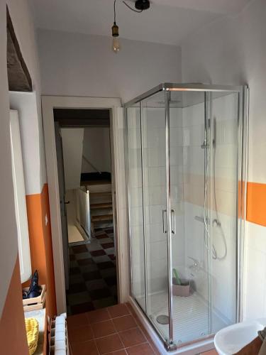 a glass shower in a bathroom with an orange at B&B MAMAOH in Fondi