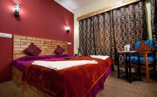 ein Schlafzimmer mit einem Bett mit einer roten Wand in der Unterkunft Hostel Inn Srinagar in Srinagar