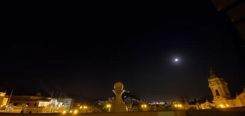 einen Blick auf eine Stadt in der Nacht mit einem Mond in der Unterkunft Hostal President in Lima