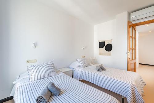2 camas en una habitación con paredes blancas en Can Marineta en Palma de Mallorca