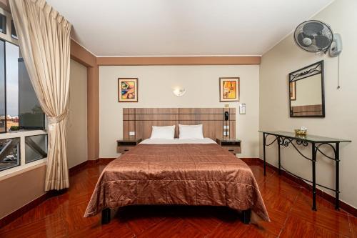 a bedroom with a bed and a large window at Hotel Bohemia in Lima