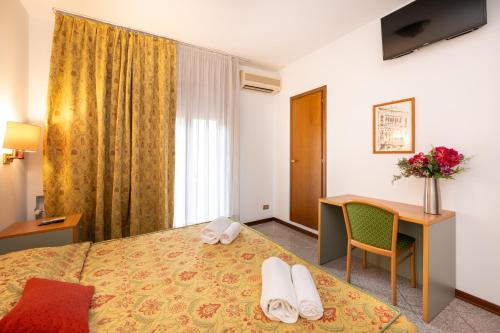 a hotel room with a bed and a desk at Camelia Rooms Venice Guesthouse in Mestre