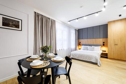 a room with a bed and a table with chairs at Apartamenty KOZIA in Gdańsk