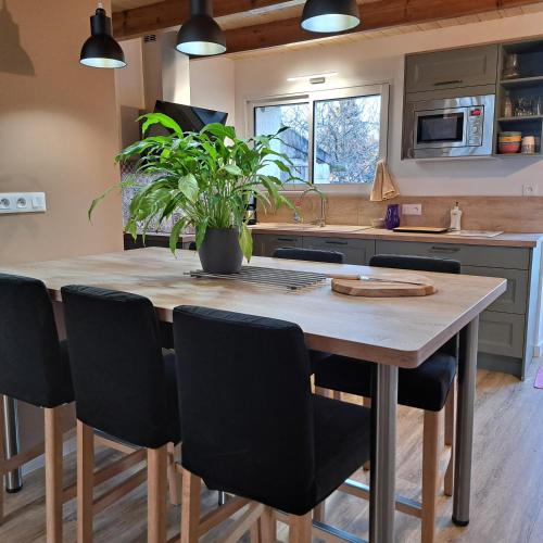 une cuisine avec une table en bois et des chaises noires dans l'établissement Au Pas de Velours, à Saint-Vaize