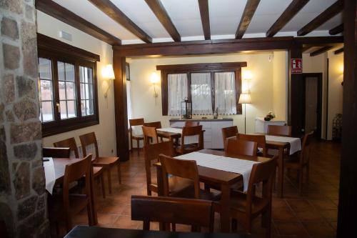 a dining room with tables and chairs and windows at El Valle Hotel Rural in Sotillo del Rincón