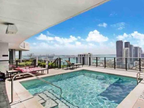 a swimming pool on a balcony with a view of the city at Canvas in Miami