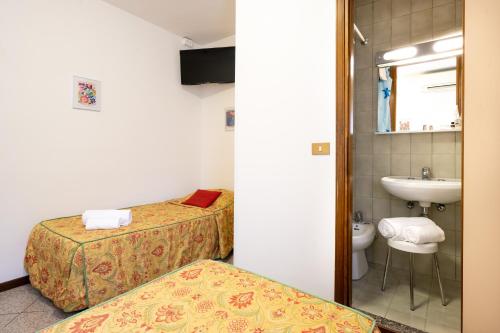 a hotel room with two beds and a sink at Camelia Rooms Venice Guesthouse in Mestre