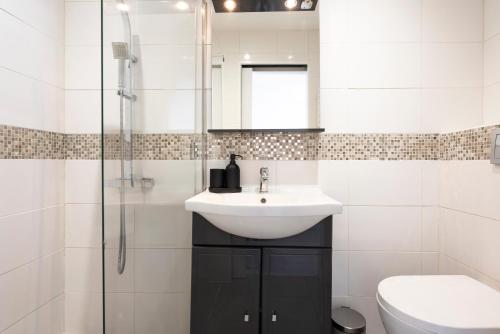 ein weißes Badezimmer mit Waschbecken und Dusche in der Unterkunft Studio centre Cannes in Cannes