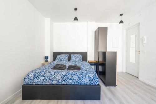 ein Schlafzimmer mit einem Bett mit einer blauen Bettdecke in der Unterkunft Studio centre Cannes in Cannes