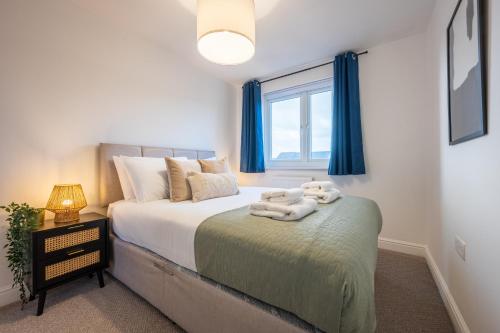 ein Schlafzimmer mit einem Bett mit Handtüchern darauf in der Unterkunft Ariel Wharf by Tŷ SA in Newport