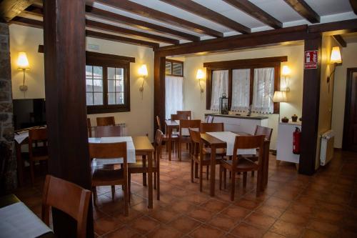un comedor con mesas y sillas en un restaurante en El Valle Hotel Rural, en Sotillo del Rincón