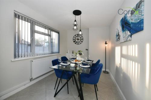 a dining room with a table and blue chairs at 3 Bedroom Tranquil Heaven for Contractors and Families Choice by Coraxe Short Stays in Tilbury
