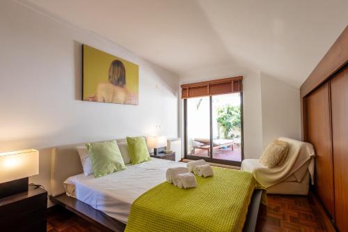 a bedroom with a bed and a table with towels on it at Caís in São Martinho do Porto