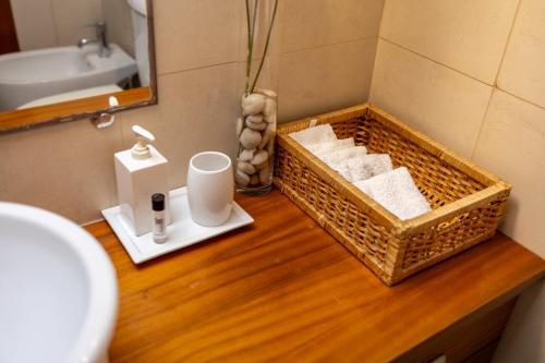 a bathroom with a basket of towels and a sink at Caís in São Martinho do Porto