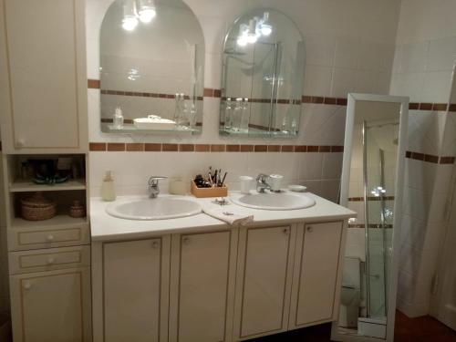 a bathroom with two sinks and two mirrors at La Casa in Cuébris
