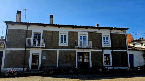 an old house with two windows and a balcony at Casa Ines in Ricobayo