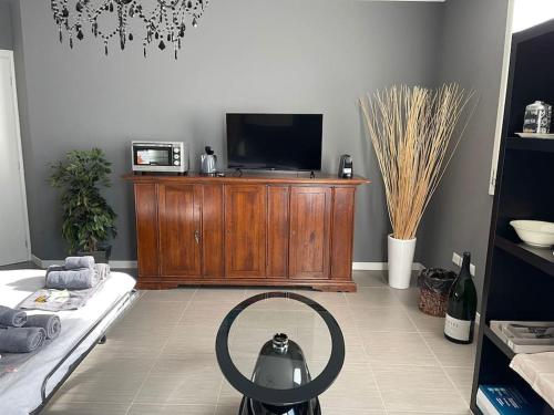 a living room with a tv on a wooden entertainment center at ERMAN HOUSE Perla nera veneziana in Dolo