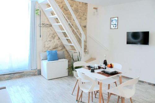 a white dining room with a white table and white chairs at Brezza Marina Ortigia in Siracusa