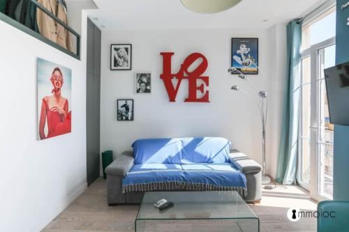 un salon avec un canapé bleu et une fenêtre dans l'établissement Port of Nice air conditioned studio, à Nice