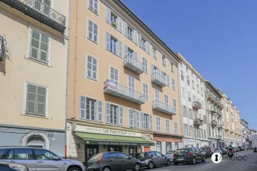 un grand bâtiment avec des voitures garées devant dans l'établissement Port of Nice air conditioned studio, à Nice