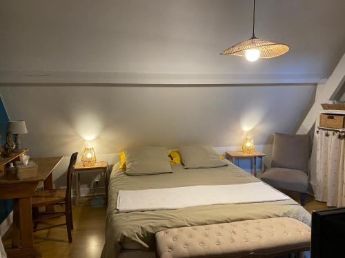 a bedroom with a bed and a desk and a chair at le jardin adele in Drucat