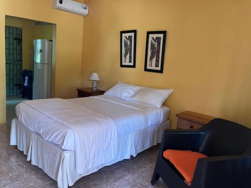 ネグリルにあるSu Casa Bonita, Negrilのベッドルーム(大きな白いベッド1台、椅子付)