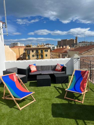 duas cadeiras de jardim e um sofá no telhado em The sunnydise Apartment LUXURY DUPLEX in the city center em Málaga