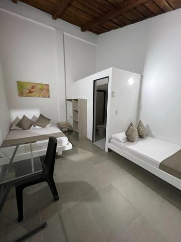 a bedroom with two beds and a desk and a chair at La Manola Finca Hotel in Doradal