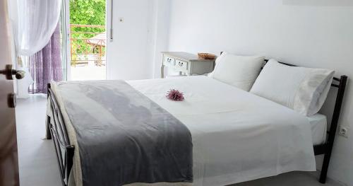 1 dormitorio con cama blanca y ventana en FBM Anagenessis - Ευ Ζην 2, en Édessa