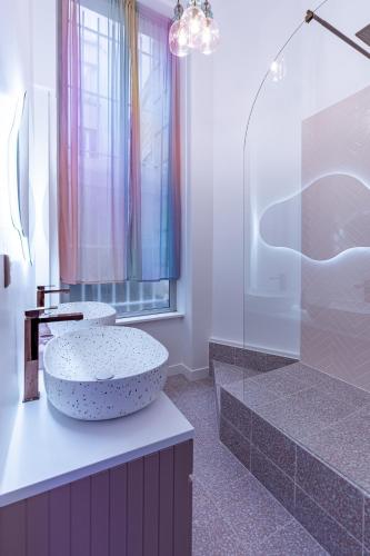 La salle de bains est pourvue d'un lavabo et d'une douche. dans l'établissement Beautiful Modern Barbie flat in Paris, à Paris