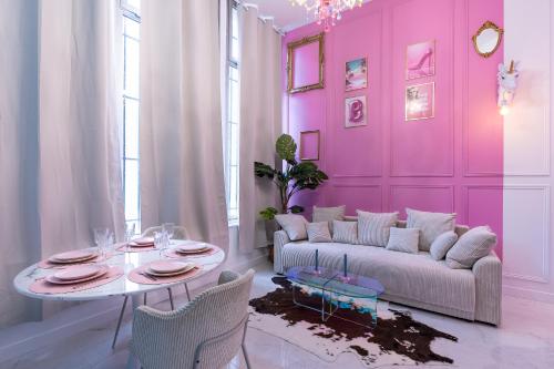 - un salon aux murs roses avec un canapé et une table dans l'établissement Beautiful Modern Barbie flat in Paris, à Paris