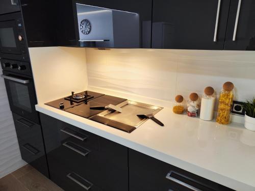 a kitchen with black cabinets and a stove at Experiencia Premium en la Esencia de Denia in Denia