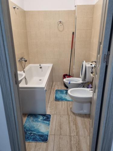 uma casa de banho com uma banheira, um WC e um lavatório. em Apartament mihaela em Râmnicu Vâlcea