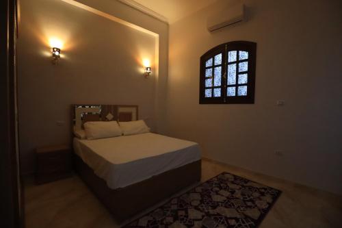 a small bedroom with a bed and a window at Ramsses Palace in Luxor