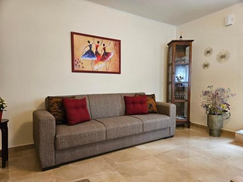 a living room with a couch and a painting on the wall at Melograno in Markopoulo