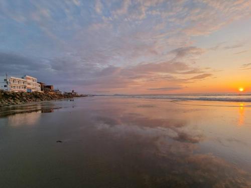 una puesta de sol en una playa con el océano en Hotel Ola Bella, en San Clemente