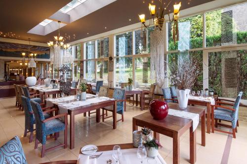 a restaurant with tables and chairs and windows at Grand Hotel Monopole in Valkenburg