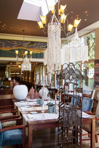 a restaurant with a long table with chairs and chandeliers at Grand Hotel Monopole in Valkenburg