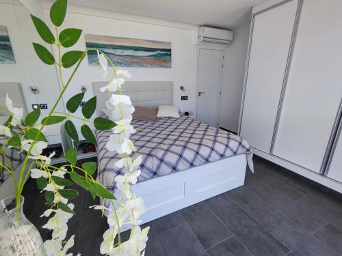 a bedroom with a bed and a plant with white flowers at Experiencia Premium en la Esencia de Denia in Denia